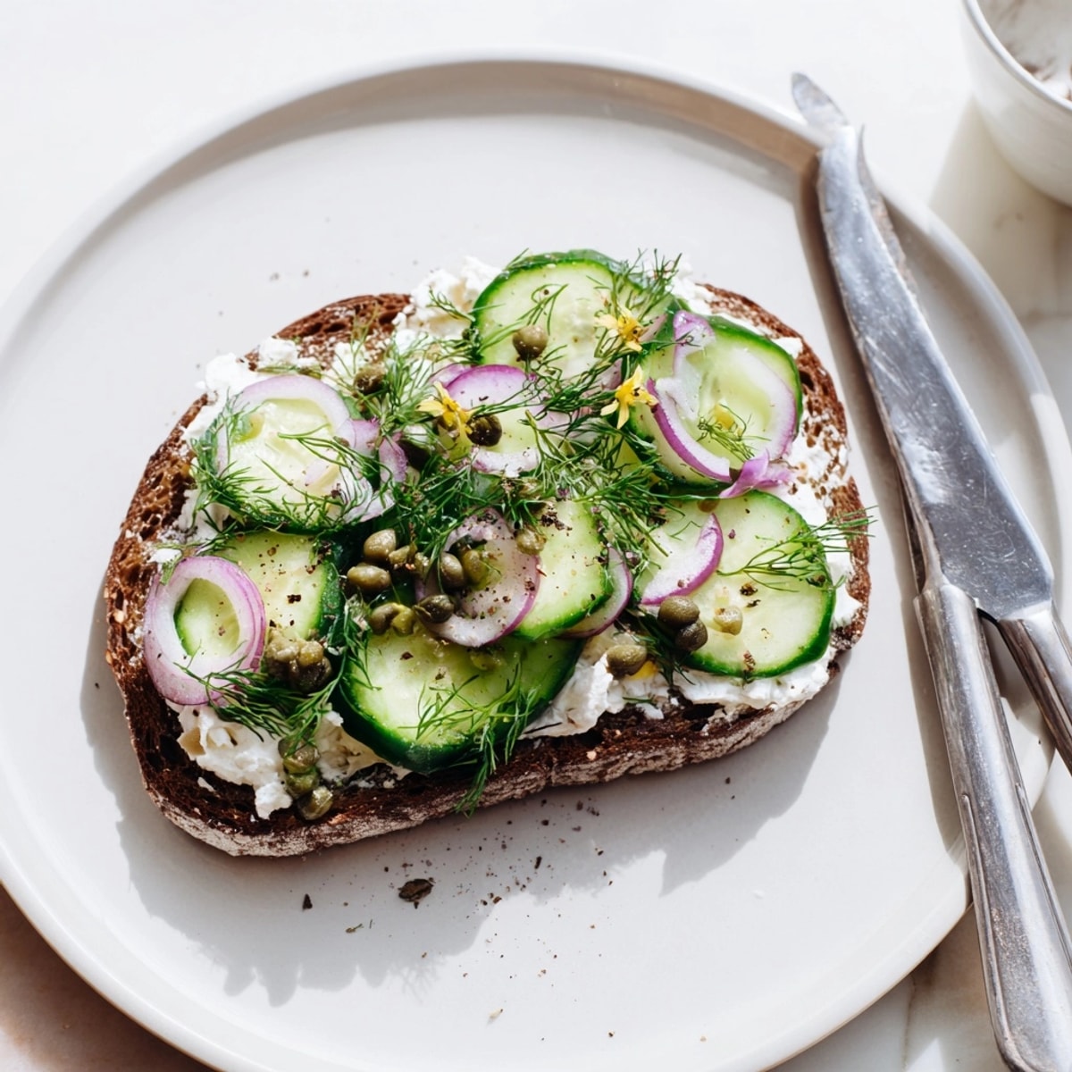 Saftige Gurken und Dill schmücken diesen rustikalen deutschen Schwarzbrot-Toast; ein schnell zubereitetes Mittagessen oder ein köstlicher Snack.