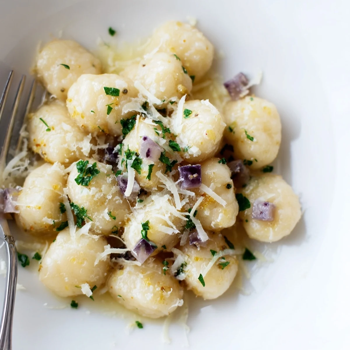 Leckere, luftige Plum Soda Gnocchi Bällchen, serviert mit frischem Parmesan und Petersilie.  