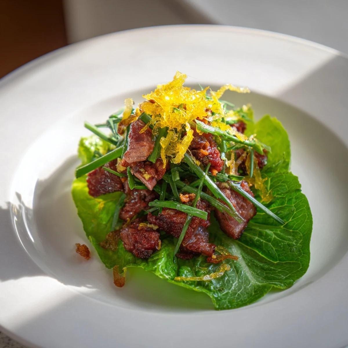 Golden, crispy Lightened Duck Confit Bites topped with fresh chives, ready to eat.