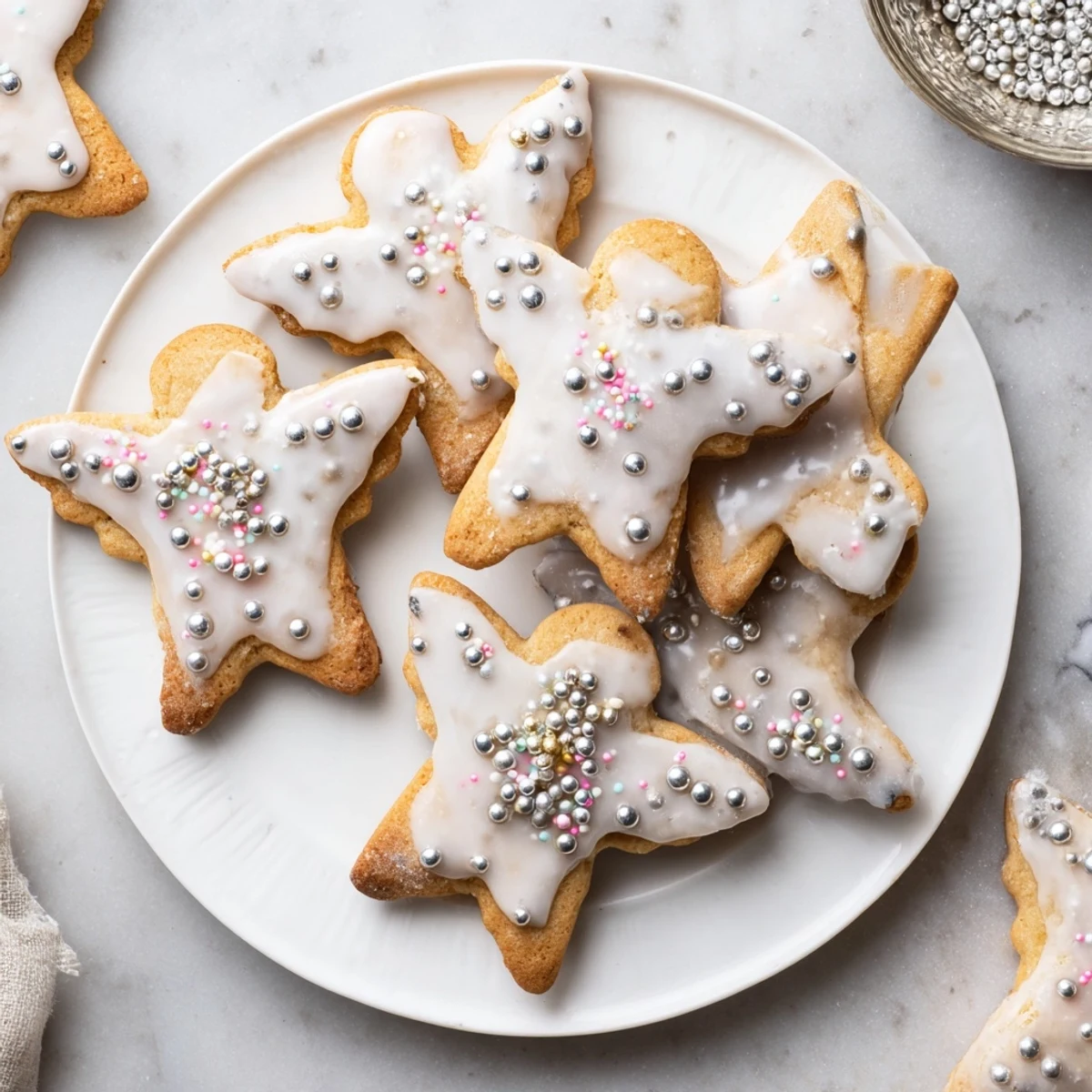 Close-up of delicately decorated Biscuits Anges de Noël with edible pearls, ready to be enjoyed.