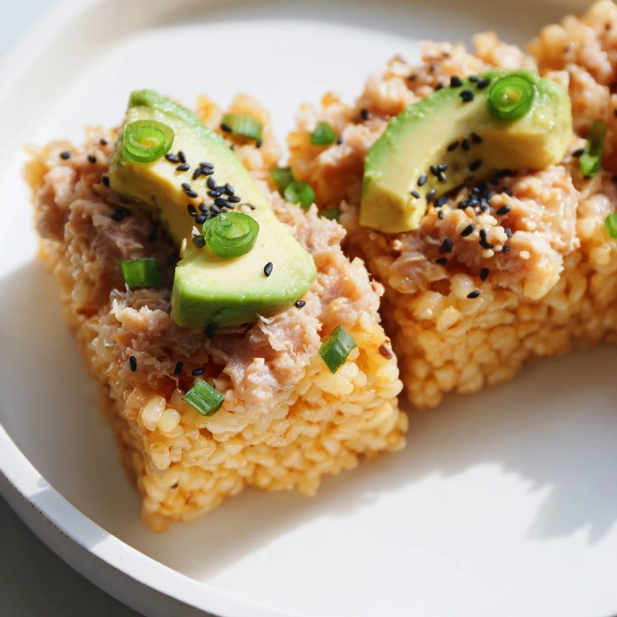 Golden-brown Spicy Tuna Crispy Rice appetizers are topped with creamy, flavorful tuna and avocado.