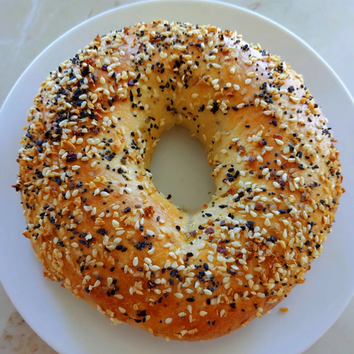 Fluffy Everything Bagel Yogurt Bagels, golden-brown and topped with savory everything bagel seasoning, ready to eat.