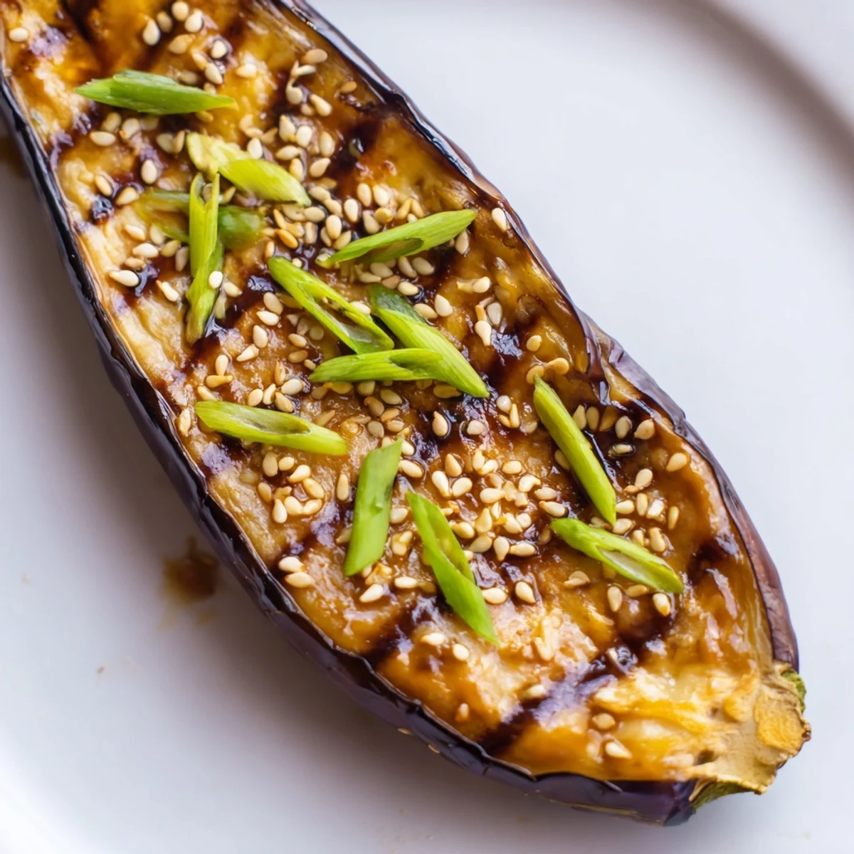 Steamed rice alongside tender Miso Glazed Eggplant topped with green onions, ready to serve.