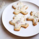 Golden baked Biscuits Anges de Noël, dusted with icing and sprinkles on a festive plate.