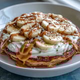 Hausgemachte High-Protein Breakfast Pizza Bowl mit goldbrauner Pancake-Basis und glatter Joghurt-Frosting-Schicht im Ofenbacktopf.