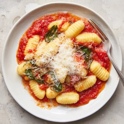 Golden-brown oven-baked homemade potato gnocchi with a rich tomato sauce, ready to be enjoyed as a hearty meal.