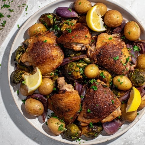 Golden-brown one-pan chicken with potatoes and Brussels sprouts, ready for a delicious dinner.