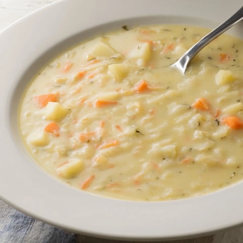 Creamy broccoli and cheese soup, garnished with a sprinkle of pepper, ready to serve in a warm bowl.