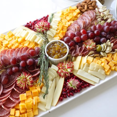 Elegant Holiday Bow Appetizer Platter boasts colorful cheeses, meats, fruits, and crackers for festive gatherings.