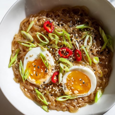 Warmes Bowl mit Shirataki Nudeln in kräftiger Knochenbrühe, garniert mit Frühlingszwiebeln und Sesam.
