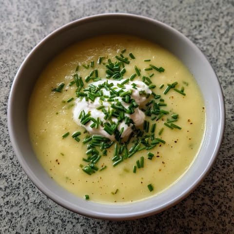 Ein weißer Teller mit einer Schüssel chilled leek and potato soup.