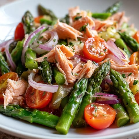 Ein weißer Teller mit einer Mischung aus Asparagus, Tomaten, Trout und Horseradish Vinaigrette.