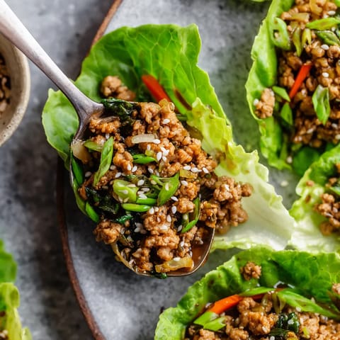 Ein Bogen Lettuce mit einer Schüssel mit Chicken-Lettuce-Wraps.