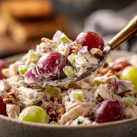 Ein Schalen mit Chicken Salat und Grapes.