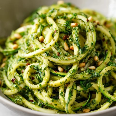 Ein großer, grüner Zucchini-Spiral auf einem Teller.