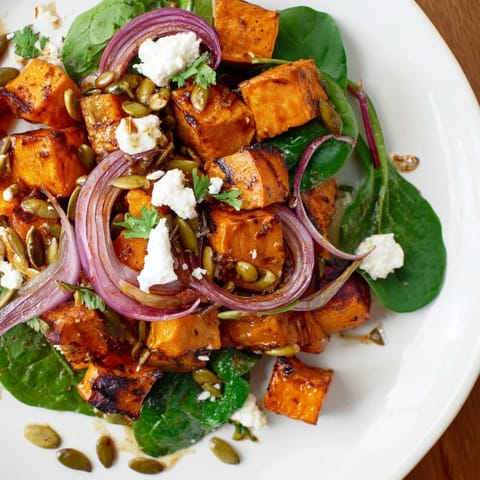 Golden sweet potatoes and toasted pumpkin seeds create a delicious Warm Roasted Sweet Potato Salad.