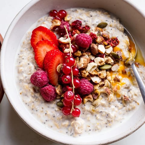 Hausgemachter Haferbrei mit Chiasamen, garniert mit saftigen roten Beeren und knackigen Nüssen, warm serviert.