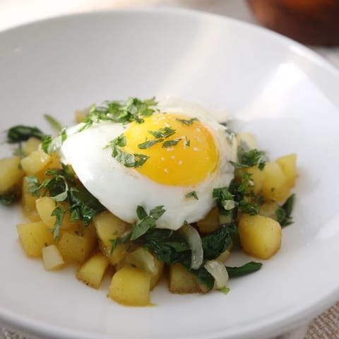 This Spinach and Potato Skillet features perfectly cooked sunny-side-up eggs and vibrant spinach.