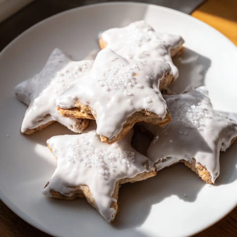 Close-up of frosted Cinnamon Stars cookies, a delightful German treat perfect for Christmas baking.