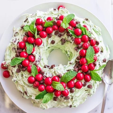 Creamy Mint Chocolate Chip Dip Wreath, festive dessert, garnished with holiday candies and fresh mint.
