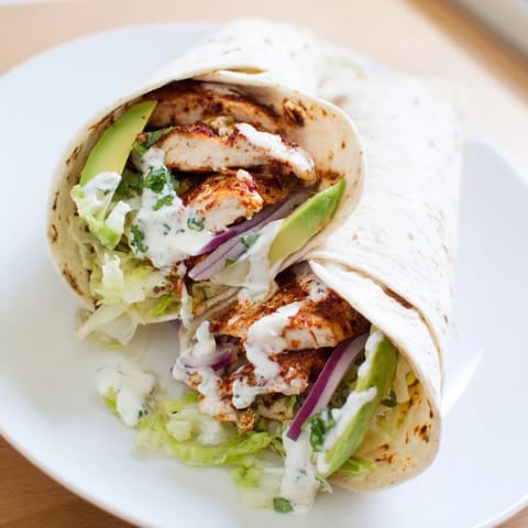 Savory smoky chipotle chicken wrap, showcasing sliced chicken and creamy avocado, perfect for lunch.