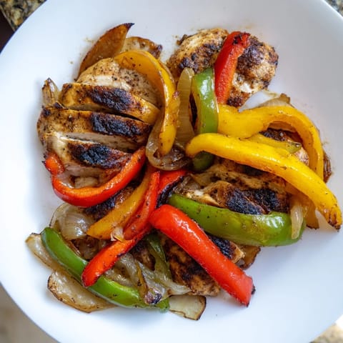 Zubereitete Easy Chicken Fajitas mit saftigem Hähnchen, Zwiebeln und cremigem Käse auf einem rustikalen Teller für den Mittagstisch.