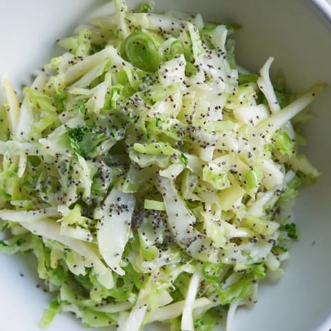 Freshly tossed Green Cabbage and Apple Slaw served in a rustic white bowl.
