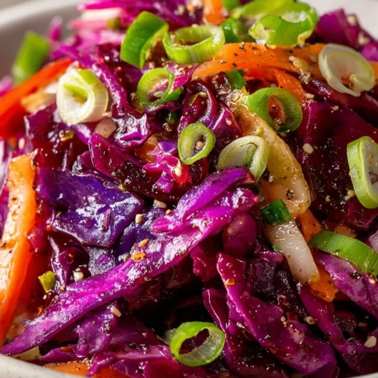 Frisch zubereiteter, einfacher roter Krautsalat mit Karotten und spritziger Vinaigrette, bereit zum Servieren als Topping.