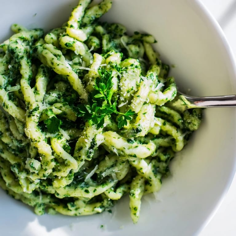 Hausgemachte Spinatspeätzle in geschmolzener Knoblauchbutter, köstlich und frisch serviert.  
