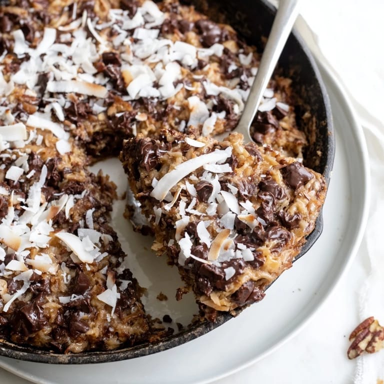 Der köstliche, warme German Chocolate Skillet Cookie mit schmelzenden Schokoladenstückchen.  
