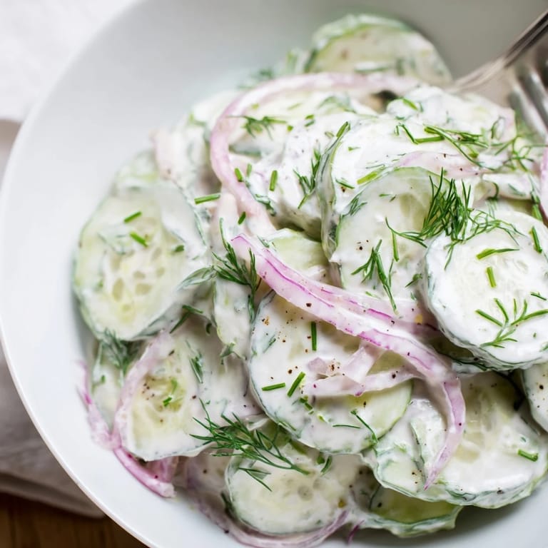 Erfrischender deutscher Gurkensalat, ideal als Beilage zu schnittigem Schweinefleisch oder Bratwürsten.