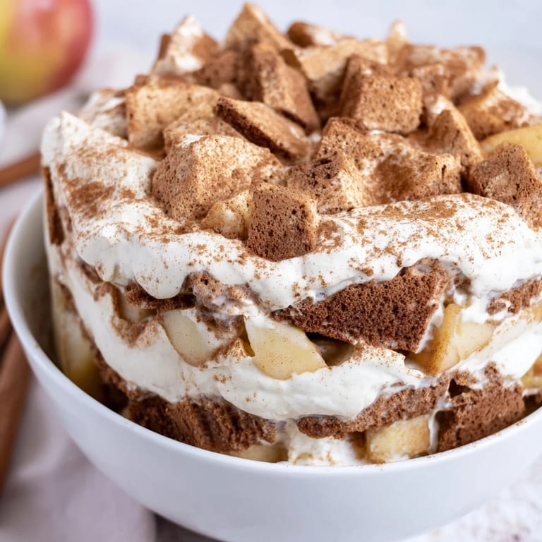 A close-up of a festive Budget Spekulatius Cookie Trifle, showing layered cookies and juicy apples.