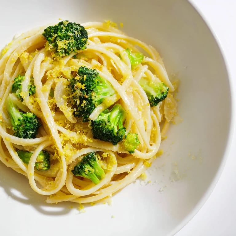 Close-up of vibrant one-pot lemon broccoli pasta, showcasing tender broccoli and a creamy sauce.