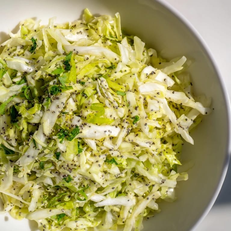Green Cabbage and Apple Slaw topped with parsley and poppy seeds for a crunchy bite.