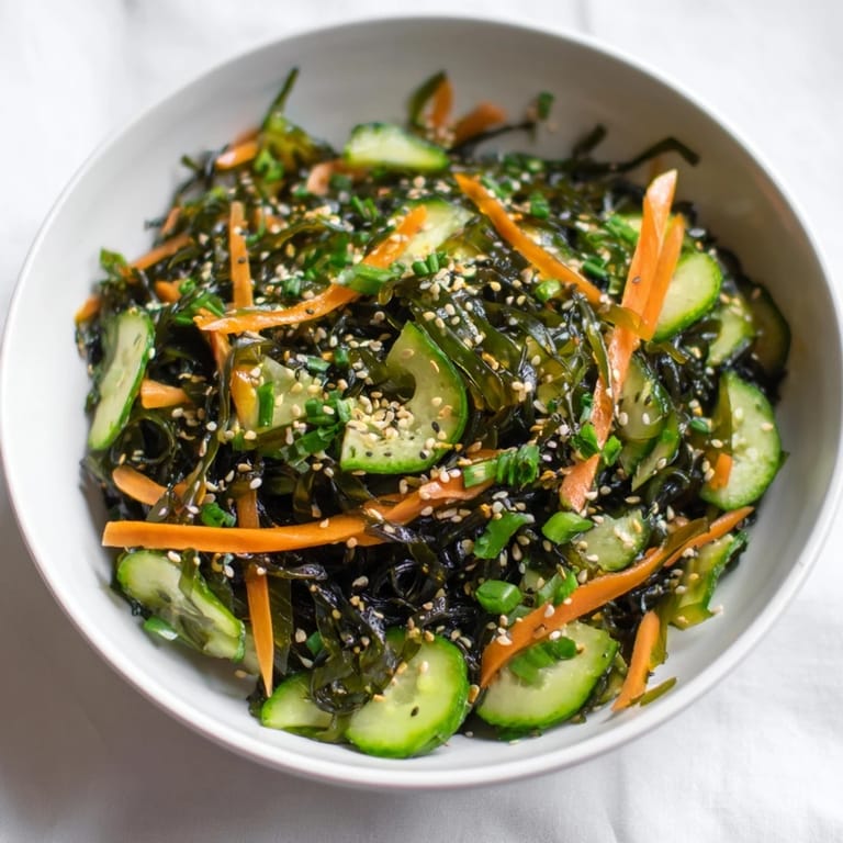 Seaweed Salad mit würziger Sesam-Ginger-Dressing und roten Chili-Flocken garniert.  