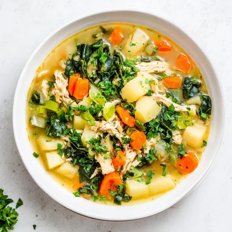 Homemade Collard Greens, Chicken and Vegetable Soup in a rustic bowl with potatoes and carrots