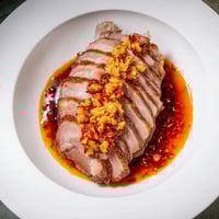 Juicy Bavarian roast pork, expertly sliced, glistening with chili-ginger sauce, ready to serve.