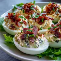 BLT Deviled Eggs mit knusprigem Bacon-Topping: cremige Eier-Hälften mit frischem Salat und Tomaten.